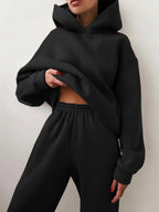 High-waisted black tracksuit set featuring an oversized hoodie and joggers, styled for a cozy, relaxed fit.