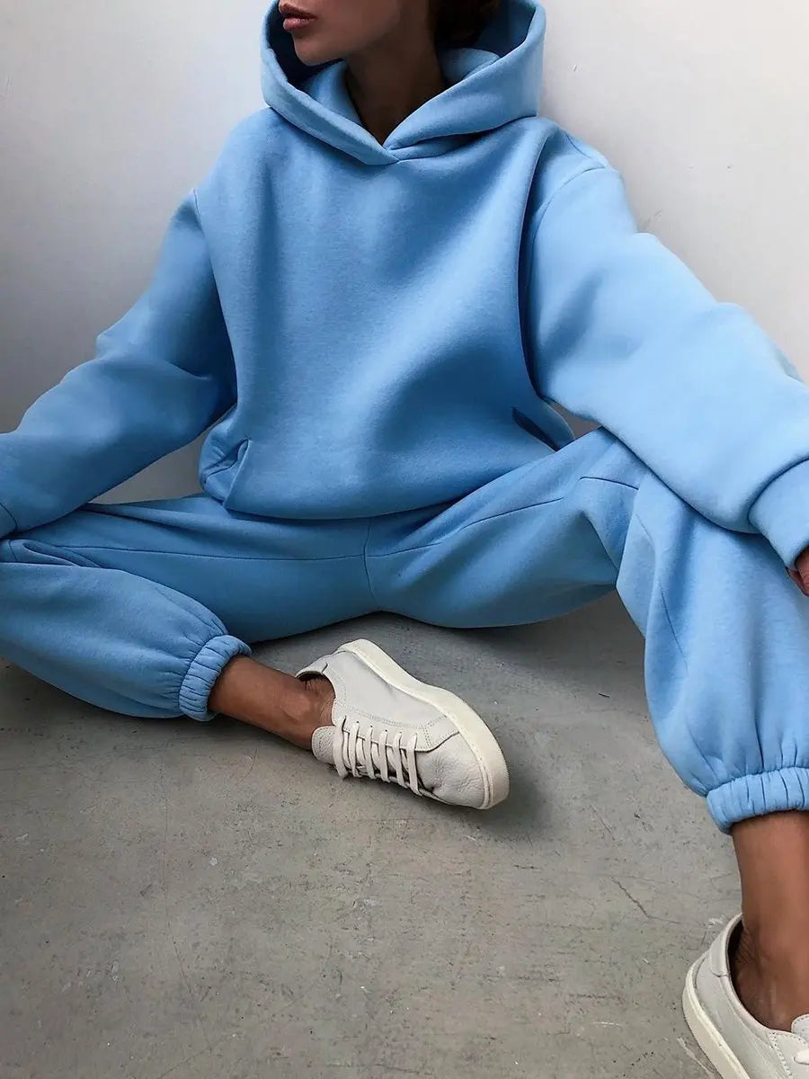 Light blue oversized pullover hoodie paired with high-waisted jogger pants, styled with cream sneakers.