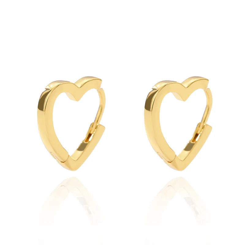Chunky gold huggie earrings in a heart drop design with a polished finish, showcasing a minimalist aesthetic.