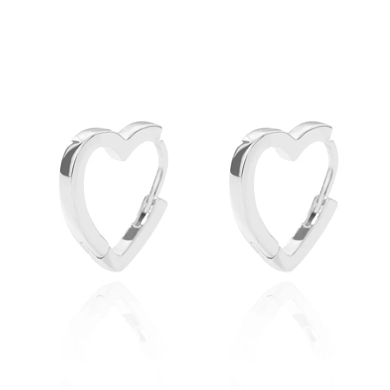 Chunky silver huggie earrings in a heart shape, featuring an open design and a polished finish.