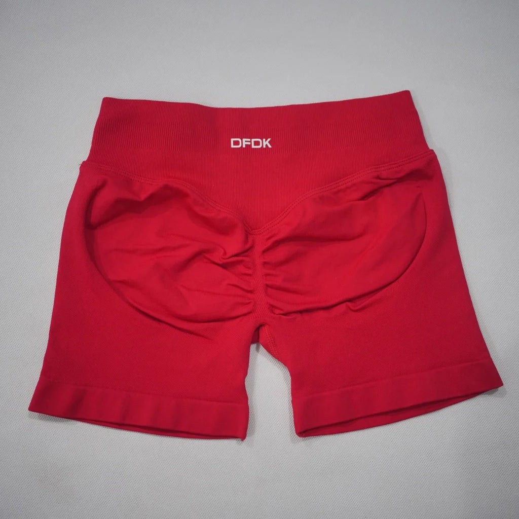 High-waisted red gym shorts featuring a scrunch-butt design and seamless fabric for a smooth fit.