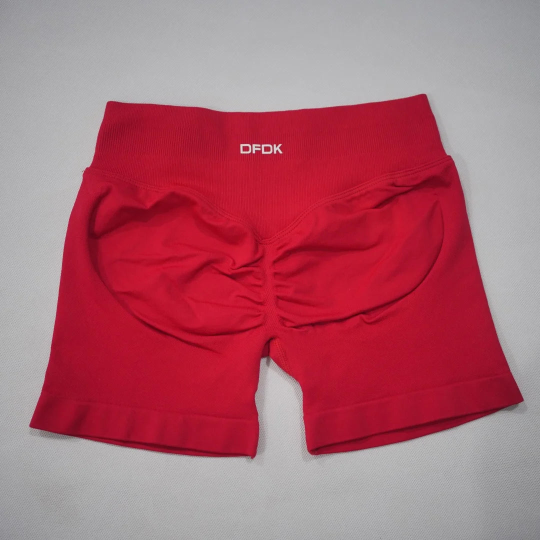 High-waisted red gym shorts featuring a scrunch-butt design and seamless fabric for a smooth fit.