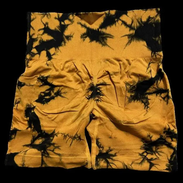 High-waisted gym shorts in a bold yellow tie-dye pattern with black accents and a scrunch butt lift design.