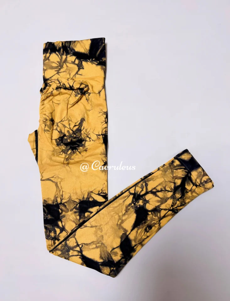 High-waisted leggings in yellow and black tie-dye pattern, featuring a seamless design and compression waistband for support.