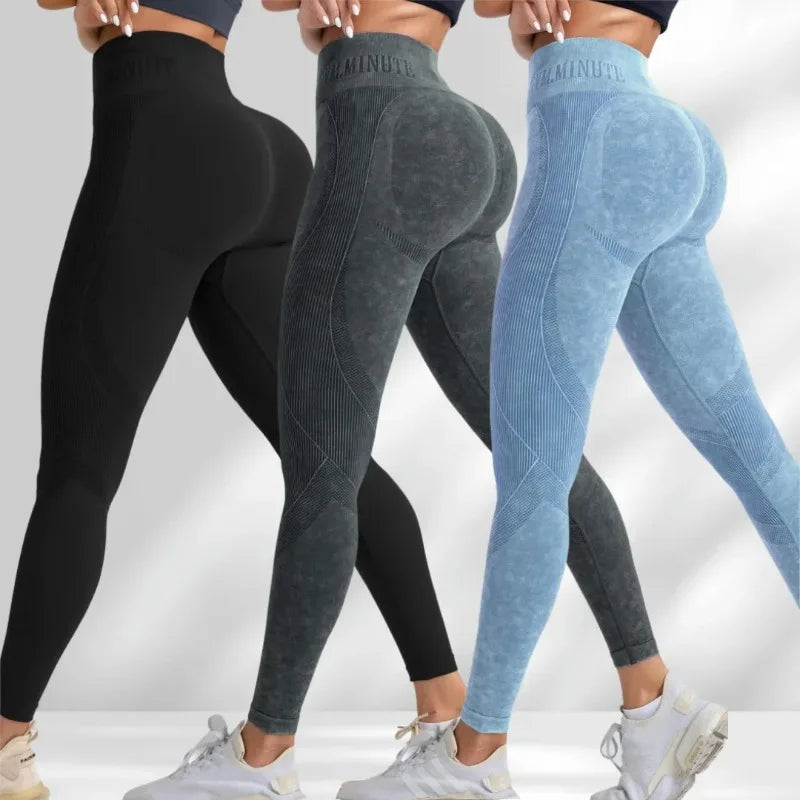 High-waisted seamless leggings in black, dark gray, and light blue with a sand-washed texture and lettered waistband.