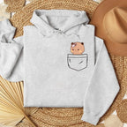 Light gray oversized hoodie featuring a cute bear graphic peeking from a front pocket. Soft, cozy material.