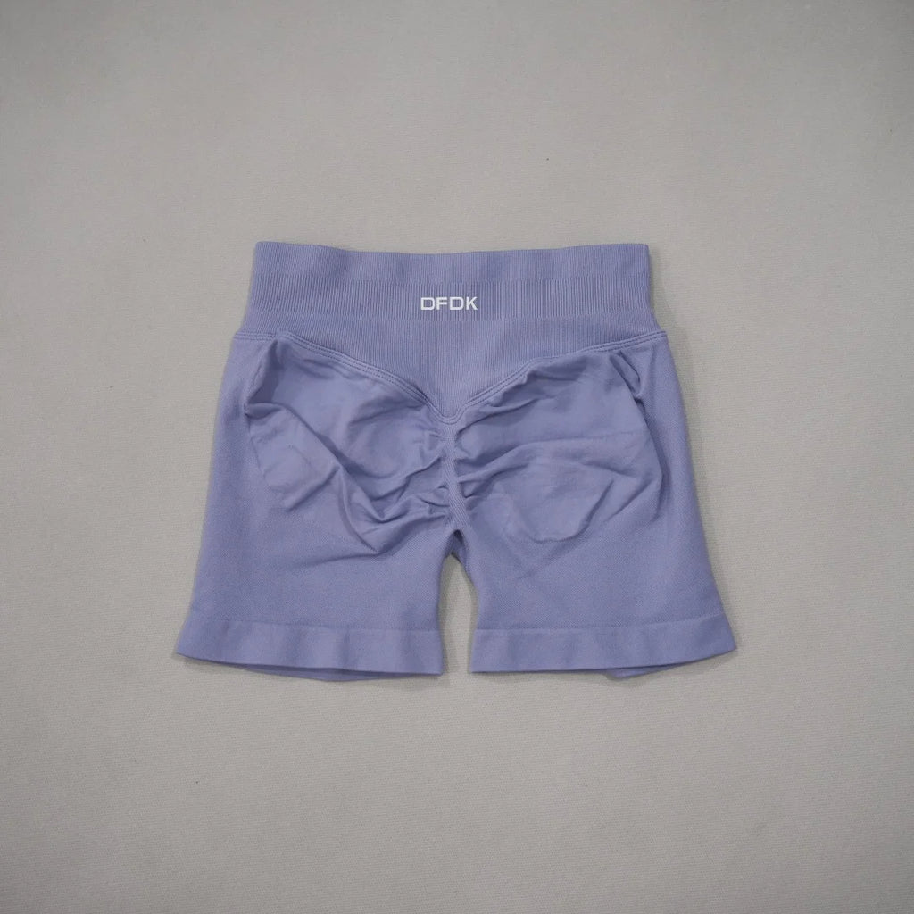 High-waisted gym shorts in light lavender with a scrunch-butt design and a wide, ribbed waistband.
