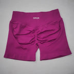 High-waisted gym shorts in a vibrant fuchsia color with a scrunch-butt design and wide, seamless waistband.