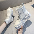 Chunky white LOVORA™ Combat Matrix boots with thick platform soles and lace-up design, shown being held against a light gray background.