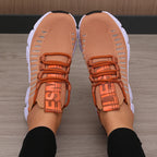 Lightweight knitted performance sneakers in a warm peach color, featuring lace-up design and breathable mesh.