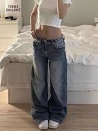 Baggy denim cargo jeans with a loose fit, mid-rise waist, and wide-leg silhouette, worn with a cropped white top.