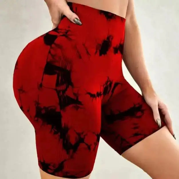 High-waisted gym shorts in a bold red and black tie-dye pattern, featuring a seamless fit and snug waistband.