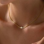 Minimalist gold cross necklace on a delicate chain, showcasing high-polish stainless steel against skin tone.