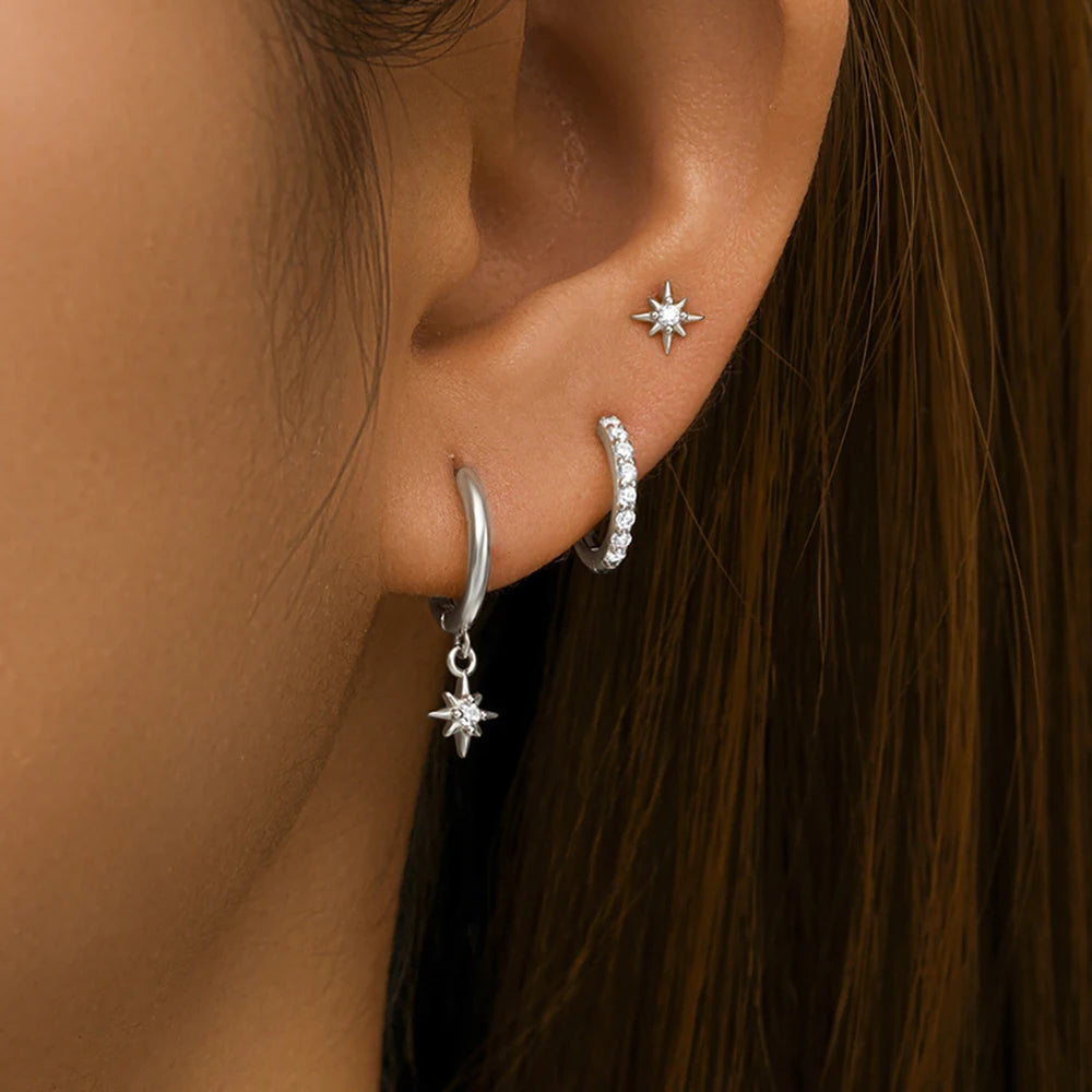 Three-piece earring set featuring high-polish stars, classic hoops, and minimalist dangles in stainless steel.