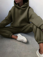 Cozy olive green high-waisted tracksuit set with an oversized hoodie and jogger pants, paired with white sneakers.