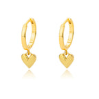 Gold huggie earrings with a chunky hoop design and a dropped heart charm, featuring a high-gloss reflective finish.