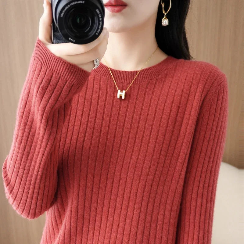 Cozy maroon ribbed pullover with a crewneck collar, worn by a model holding a camera; paired with a gold necklace.