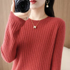 Cozy maroon ribbed pullover with a crewneck collar, worn by a model holding a camera; paired with a gold necklace.