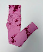 High-waisted, pink and burgundy tie-dye seamless leggings featuring a wide compression waistband and smooth finish.