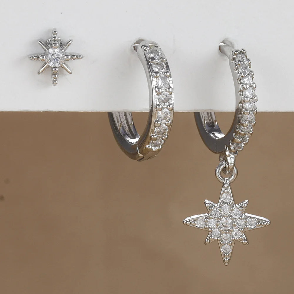 Three-piece earring set featuring high-polish star stud, sparkling hoop, and minimalist drop earring. Silver-tone finish.