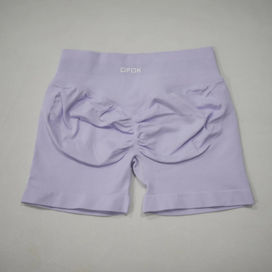 High-waisted gym shorts in light lavender, featuring a seamless design and a scrunch-butt detail for added contour.