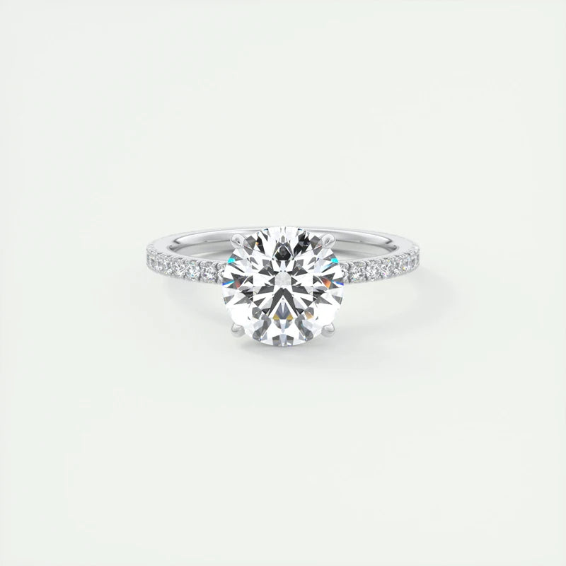 Round-cut Moissanite gemstone ring with a six-prong setting, featuring a silver band and subtle shimmering details.