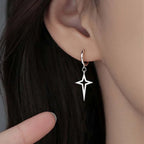Gothic Cyber-Punk Hollow Star Drop Earrings dangling from an ear, featuring a metallic star design in dark silver tone.