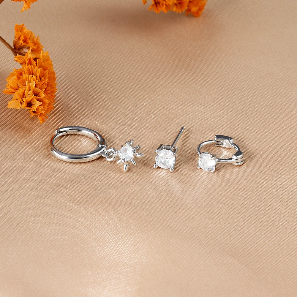 Three-piece earring set featuring a silver hoop with a star charm, a stud earring, and a small hoop, all with clear stones.