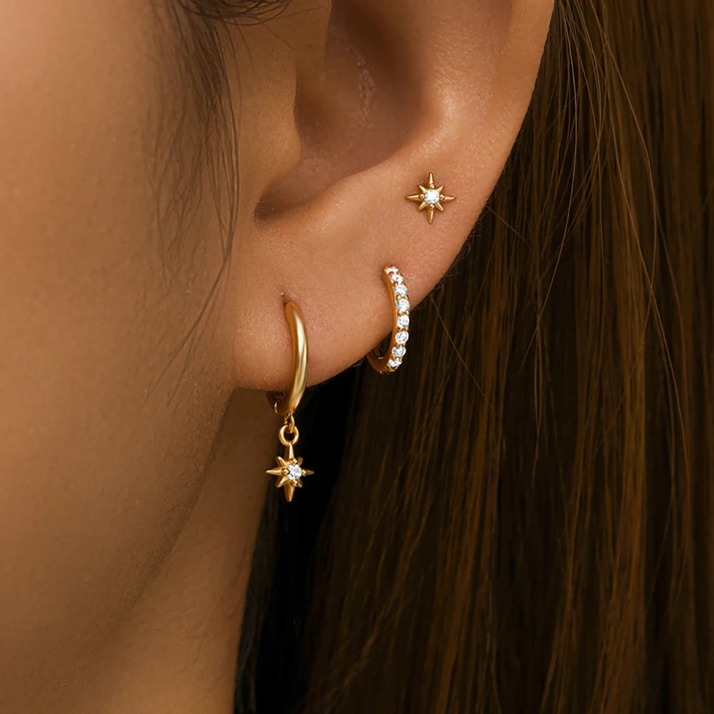 Three-piece earring set featuring geometric designs in 18K gold, with a star dangle, hoop, and rhinestone accent.