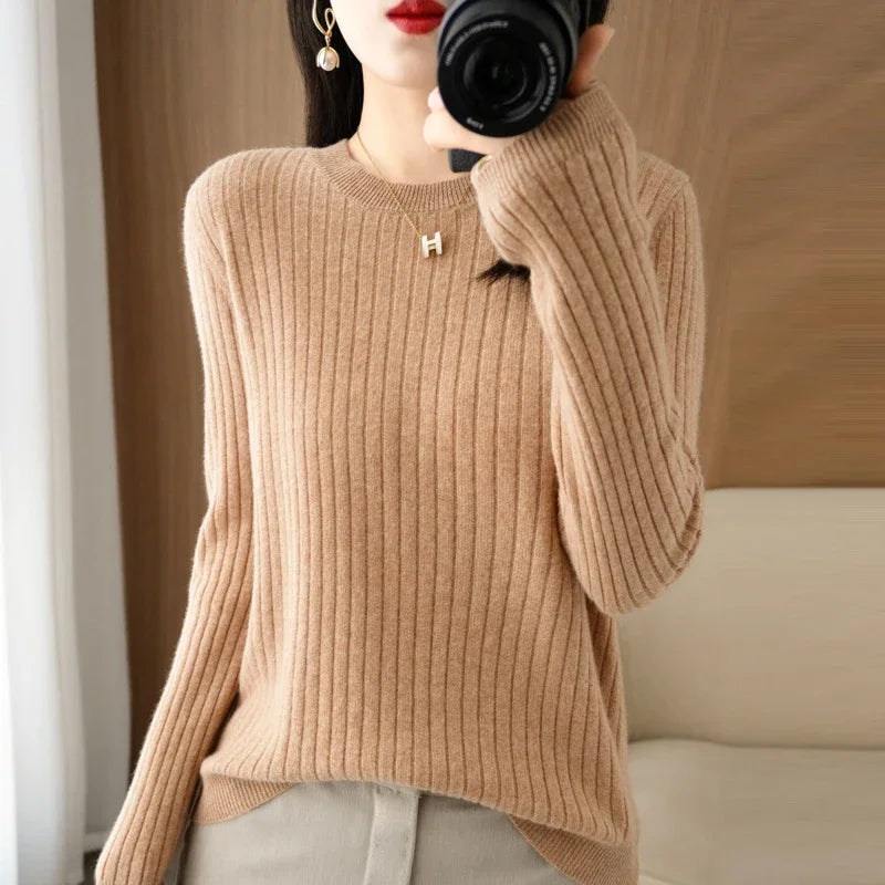 Cozy beige ribbed pullover with a crewneck, worn with relaxed sleeves, showcasing a soft knit texture.