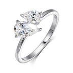 Sterling silver ring featuring two pear-cut moissanite gemstones in a sleek, asymmetric design.