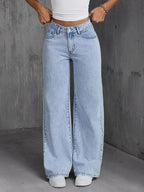 Light wash high-waisted wide-leg denim jeans featuring a relaxed fit and classic pockets, styled with a fitted white top.