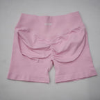 High-waisted gym shorts in light pink featuring a scrunch-butt design and a wide elastic waistband for comfort.
