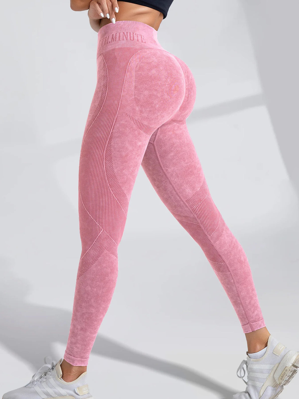 High-waisted seamless leggings in a soft pink sand-washed texture, featuring a supportive waistband and accent detailing.