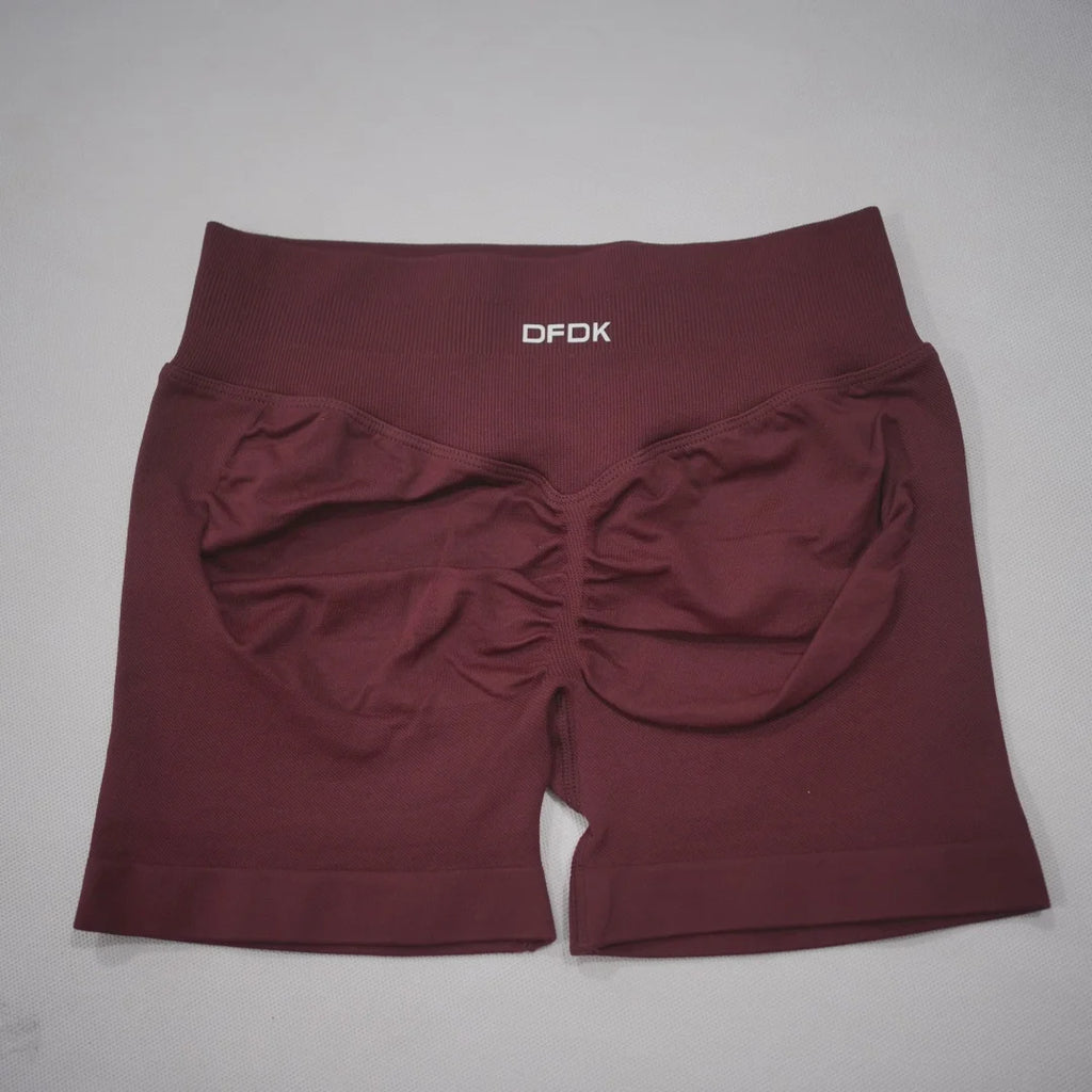 Burgundy high-waisted gym shorts with a scrunch-butt design and wide waistband, made from seamless nylon and spandex blend.