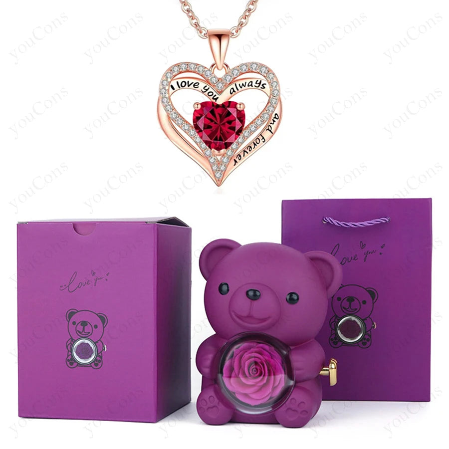 Heart-shaped red pendant necklace with sparkling accents, accompanied by a purple bear holding a preserved rose, in a luxury gift box.