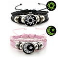 Multi-layered leather bracelet set featuring black and pink bands. Each adorned with a sun or moon token on a braided design.