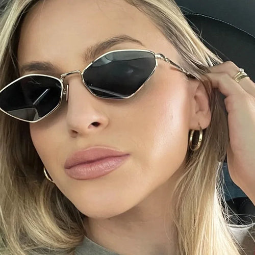 Polygonal metal sunglasses with diamond-cut black lenses and sleek metallic temples, worn with a casual outfit.