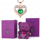 Luxury heart necklace set featuring a green gem heart pendant, a purple bear holder with a preserved rose, and purple gift box.