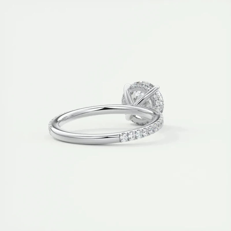 A 2-carat round-cut Moissanite solitaire ring with a six-prong crown and a sleek band featuring small accent stones.