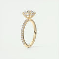 Elegant 2 carat round-cut Moissanite ring in a polished yellow gold setting with a sparkling band of smaller stones.