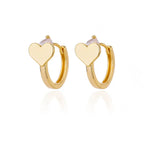 Chunky gold huggie earrings feature a heart drop design with a smooth finish and a secure snap-lock closure.