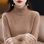 Premium merino wool and cashmere turtleneck sweater in a warm tan color, featuring a relaxed high collar and ribbed trims.