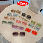 Rimless Y2K rectangle sunglasses in assorted colors, featuring narrow gradient lenses and metallic accents, displayed on a table.