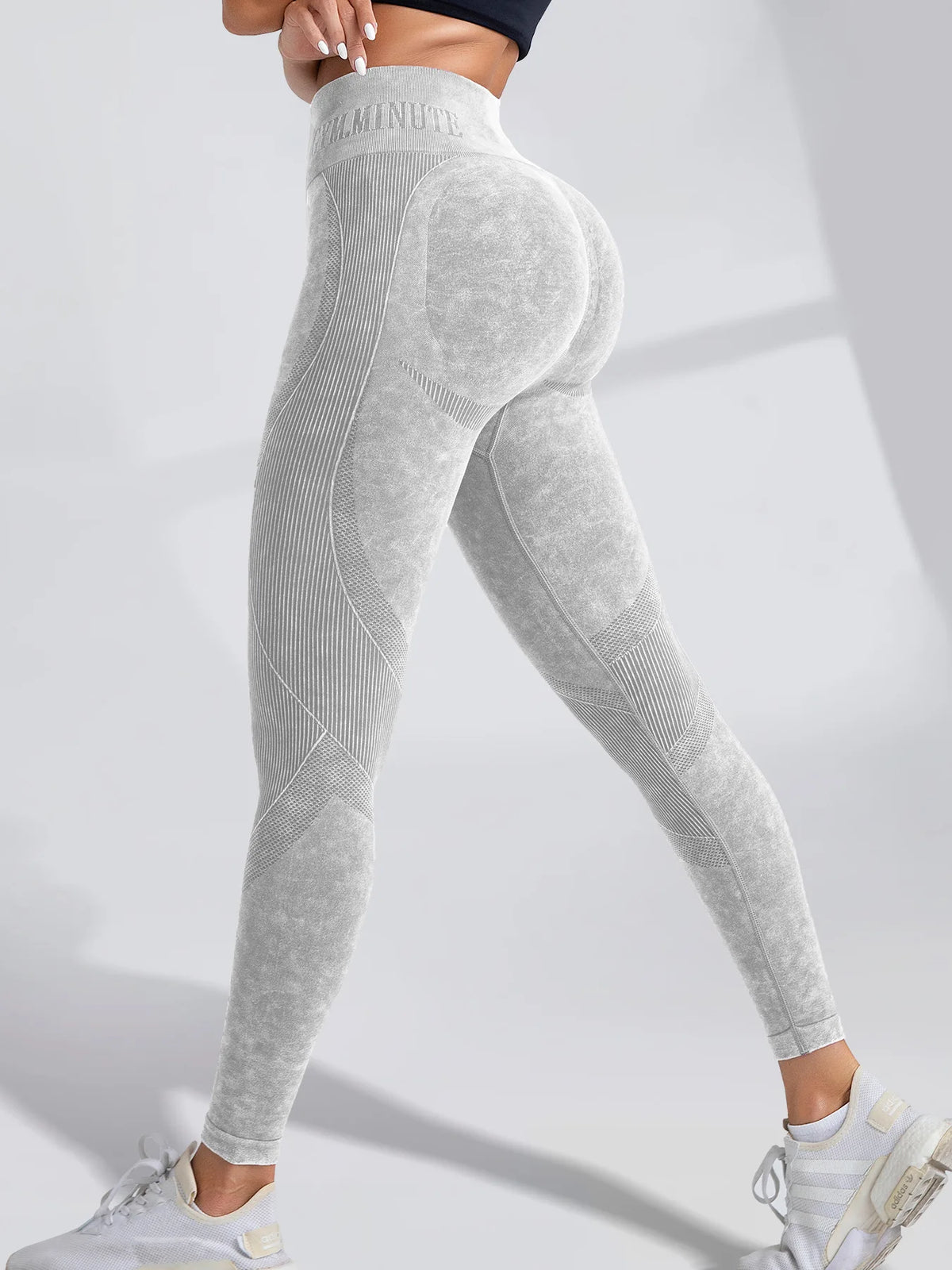 High-waisted, seamless gray leggings with a sand-washed texture and ribbed accents, styled with a cropped top and sneakers.