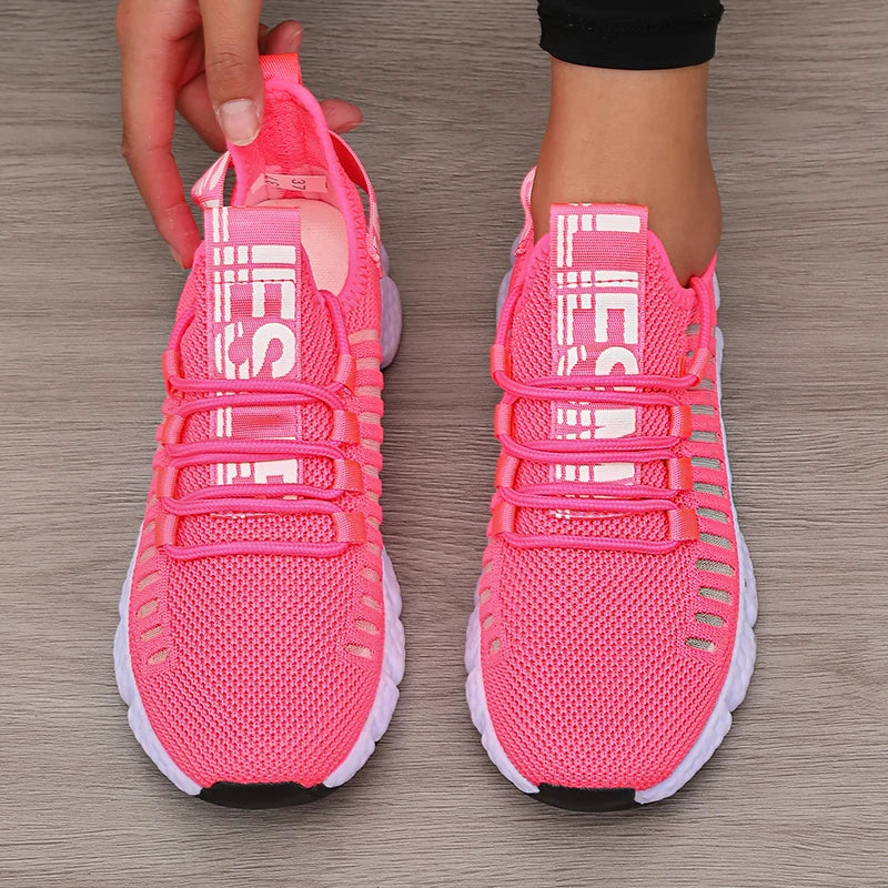 Bright pink LOVORA™ Aura Breathable Knitted Performance Sneakers feature a slip-on design and lace-up detail, showcasing a lightweight mesh upper.