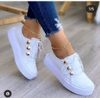 White LOVORA™ Classic Leather Platform Casual Sneakers with gold button accents, worn with distressed blue jeans and ankle chain.