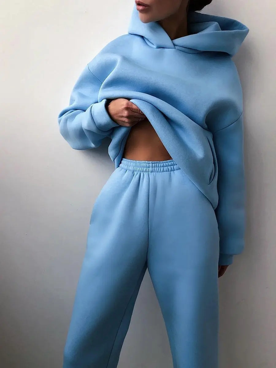High-waisted light blue tracksuit set featuring an oversized pullover hoodie and matching joggers, showcasing a cozy fit.
