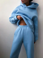 High-waisted light blue tracksuit set featuring an oversized pullover hoodie and matching joggers, showcasing a cozy fit.