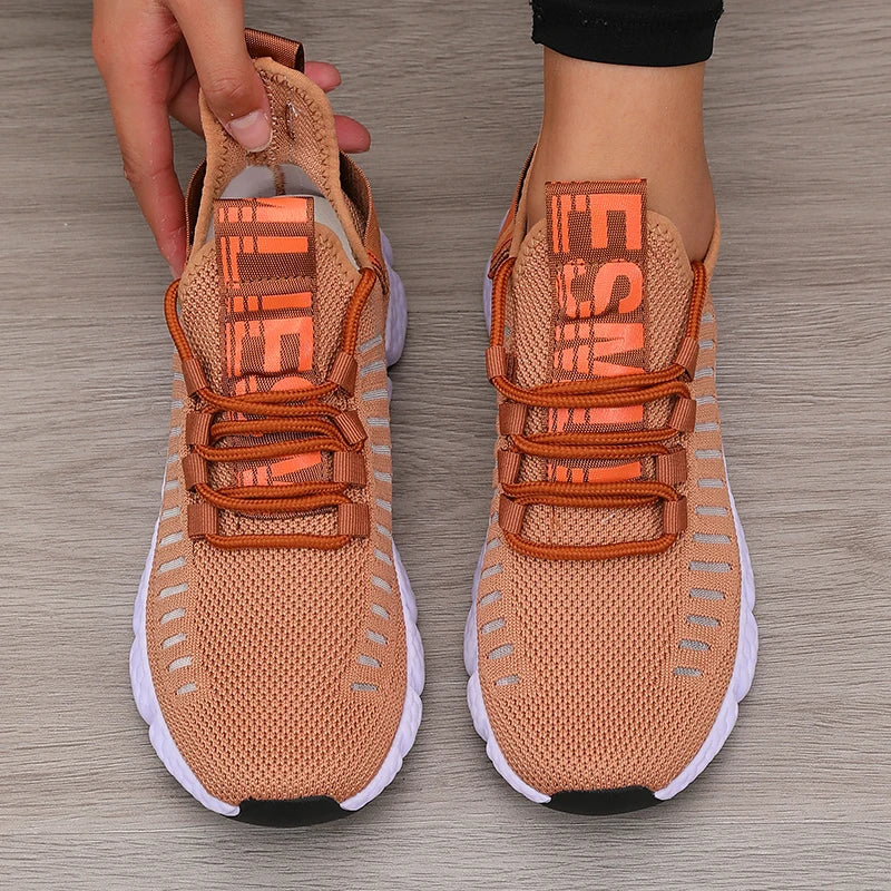 Knitted performance sneakers in a peach color with a breathable mesh upper, featuring a lace-up system and a lightweight outsole.